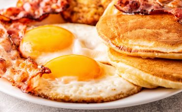 Healthy Full American Breakfast with Eggs Bacon Pancakes and Lat